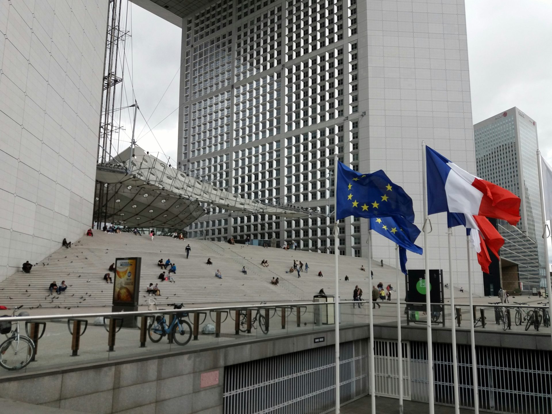 a group of flags flying in front of a building